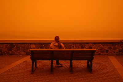 CRETE, GREECE - APRIL 1: A woman sits on a bench as Crete is cloaked by Saharan dust storm in Greece on April 1, 2026. (Photo by Stefanos Rapanis/Anadolu via Getty Images)