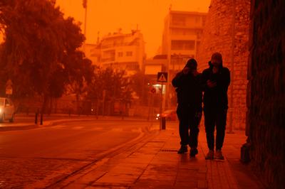 CRETE, GREECE - APRIL 1: People cover themselves to protect from dust as Crete is cloaked by Saharan dust storm in Greece on April 1, 2026. (Photo by Stefanos Rapanis/Anadolu via Getty Images)