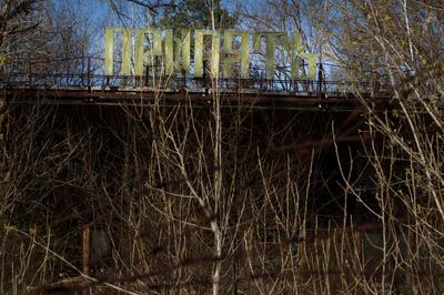 The dilapidated Prypiat cafe is visible behind trees in Prypiat, a city abandoned due to the Chornobyl disaster, in the Kyiv region, Ukraine, on April 14, 2026. April 26, 2026, marks the 40th anniversary of the explosion of the fourth reactor at the Chornobyl Nuclear Power Plant, which occurred on April 26, 1986. The accident is considered one of the most significant events in the history of nuclear energy. (Photo by Kyrylo Chubotin/Ukrinform/NurPhoto via Getty Images)