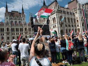 BUDAPEST, HUNGARY - MAY 09: A supporter of Hungary’s incoming Prime Minister Peter Magyar waves a flag with his portrait as the public watches the first session of Parliament from outside the Hungarian Parliament on the day Tisza Party leader Peter Magyar is sworn in as prime minister on May 09, 2026 in Budapest, Hungary. The victory of Magyar's Tisza Party in last month's parliamentary election brought an end to the 16-year rule of the Fidesz party and prime minister Viktor Orban. (Photo by John Moore/Getty Images)