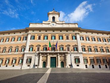 Palazzo Montecitoro, seat of the Italian Chamber of Deputies, is a parliament building in Rome, Italy. Originally designed by Bernini, the baroque palace architecture was completed by Carlo Fontana, who added the bell gable above the facade main entrance. The multi-story built structure is a center for government politics and policy.