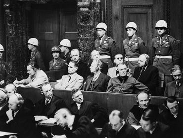 (Original Caption) 1/29/1945-Nuremberg, Germany: Top Nazi leaders on trial in the Nuremberg Palace of Justice are interested as prosecutors begin introducing documents on the third day of the trial. Goering is interested enough to take notes. Pictured (L to R) are Hermann Goering, Rudolf Hess, Joachim von Ribbentrop, Generel Wilhelm Keitel (in front row); and Admirals Karl Doenitz and Erich Raeder, Baldur von Schirach, and Fritz Sauckel (in back row).