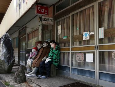 madárijesztő bábuk egy bezárt üzlethelyiség előtt Japánban