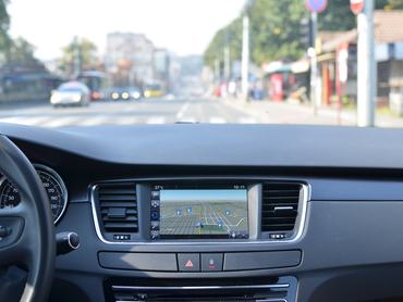 Kilátás egy autó belsejéből a műszerfal egy részére navigációs egységgel
