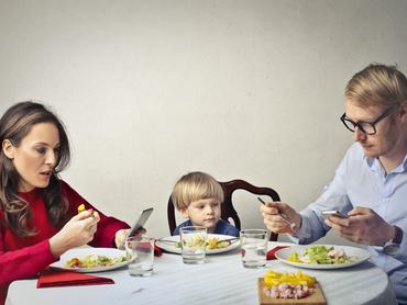 A szülők a telefonjukat használják vacsora közben