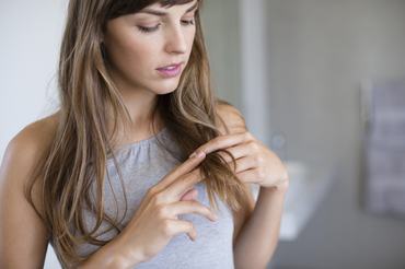 woman looking at her hair