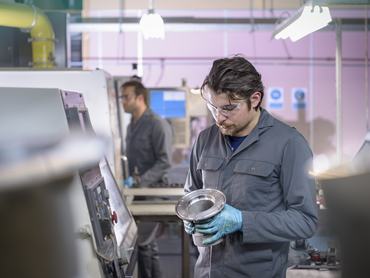 Engineer finishing aluminium component in precision casting factory