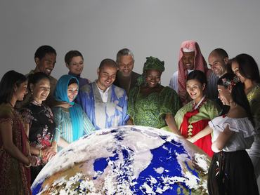 Különböző népcsoportú emberek tradícionális ruhában körbeállják a Földet