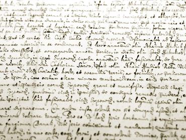 Detail of an old medieval  manuscript in sepia, shallow depth of field