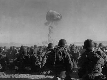 Az amerikai hadsereg 11. légideszant-hadosztályának katonái figyelik, ahogy 1951. november 1-jén radioaktív füstfelhő emelkedik a nevadai Yucca Flats-i atomrobbantás után.