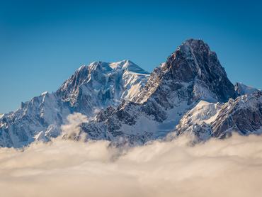 Mont Blanc and Grandes Jorasses above the winter clouds in the valley.