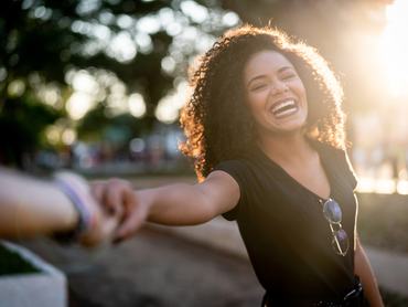 Egy mosolygós nő fogja párja kezét