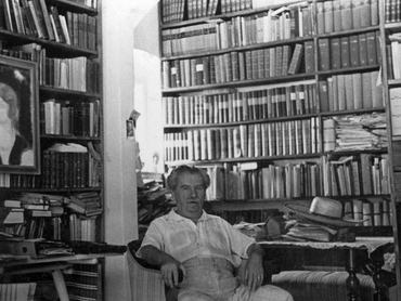 Móricz Zsigmond könyvespolca előtt, leényfalui otthonában