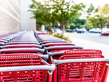 Many rows of red shopping carts outside by store with closeup by parking lot