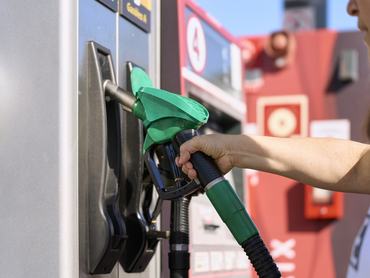 Egy nő megtankolja az autóját a benzinkúton