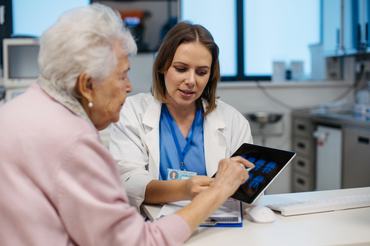 Orvos magyarázza az idősebb betegnek az agyi MRI-vizsgálat eredményeit. Betegségek diagnosztizálása idős embereknél. Agyvizsgálat, stroke, demencia, fejsérülések vagy idegrendszeri rendellenességek felismerése.