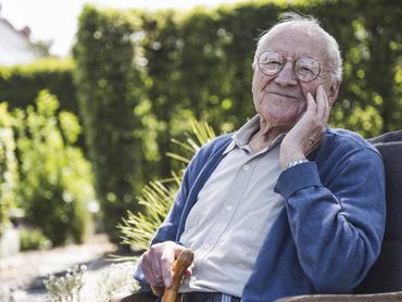 Mosolygó idős férfi karosszékben ülve