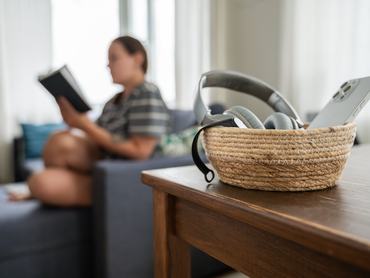 Félrerakott telefon egy kosárban, mert a kanapén fekvő nő digitális detoxot tart