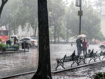 Életkép egy városi utcán amint hevesen esik az eső