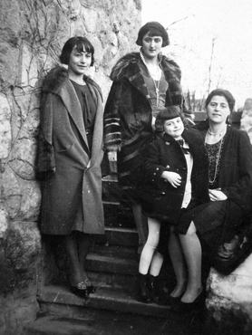 3 nő és egy kislány áll egy lépcsőn, 1927-ben. A nők bubifrizurát, szoknyát és bundát viselnek.