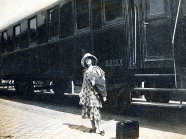 hölgy kalapban és nyári ruhában egy vonat előtt, 1930