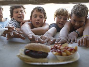 Gyerekek nyúlnak egy adag hamburger után