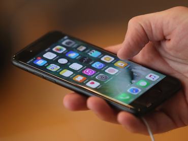 BERLIN, NÉMETORSZÁG – SZEptember 16.: Egy látogató kipróbálja az Apple iPhone 7-et a készülék értékesítésének első napján a berlini Apple Store-ban 2016. szeptember 16-án, Berlinben, Németországban. Az új telefon két méretben kapható: az egyik 4,7 hüvelykes, a másik 5,5 hüvelykes kijelzővel.   (Fotó: Sean Gallup/Getty Images)