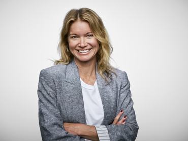 Magabiztos üzletasszony mosolyog fehér háttér előtt