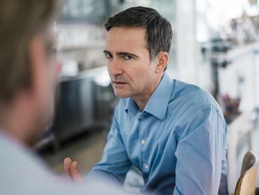 Egy középkorú férfi komolyan néz a kollégájára a munkahelyen