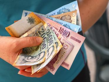 Magyar pénz, egy nő egy marék magyar forintot tart a kezében, különböző bankjegyek, pénzügyek