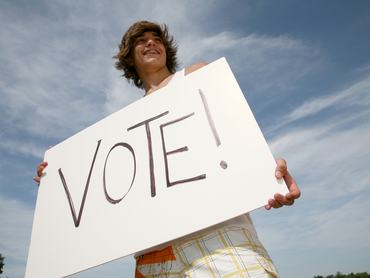 A young teenager with a vote sign.