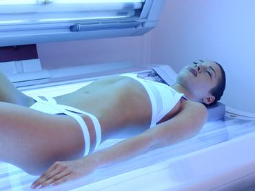 Egy fiatal nő szoláriumban barnul