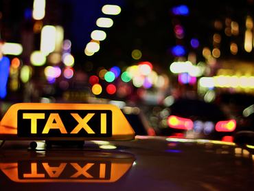 Színes bokeh, előtérben egy taxi jelzése.