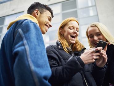 Fiatalok nézik egy mobiltelefon képernyőjét