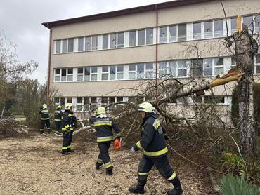 Vihar miatt kidőlt fát távolítanak el egy épület mellől a tűzoltók Vas vármegyében