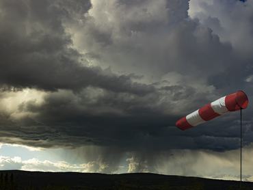 Viharfelhők a láthatáron, előtérben egy szélzsákkal